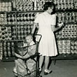 woman shopping in Canal Zone commissary with baby in shopping cart